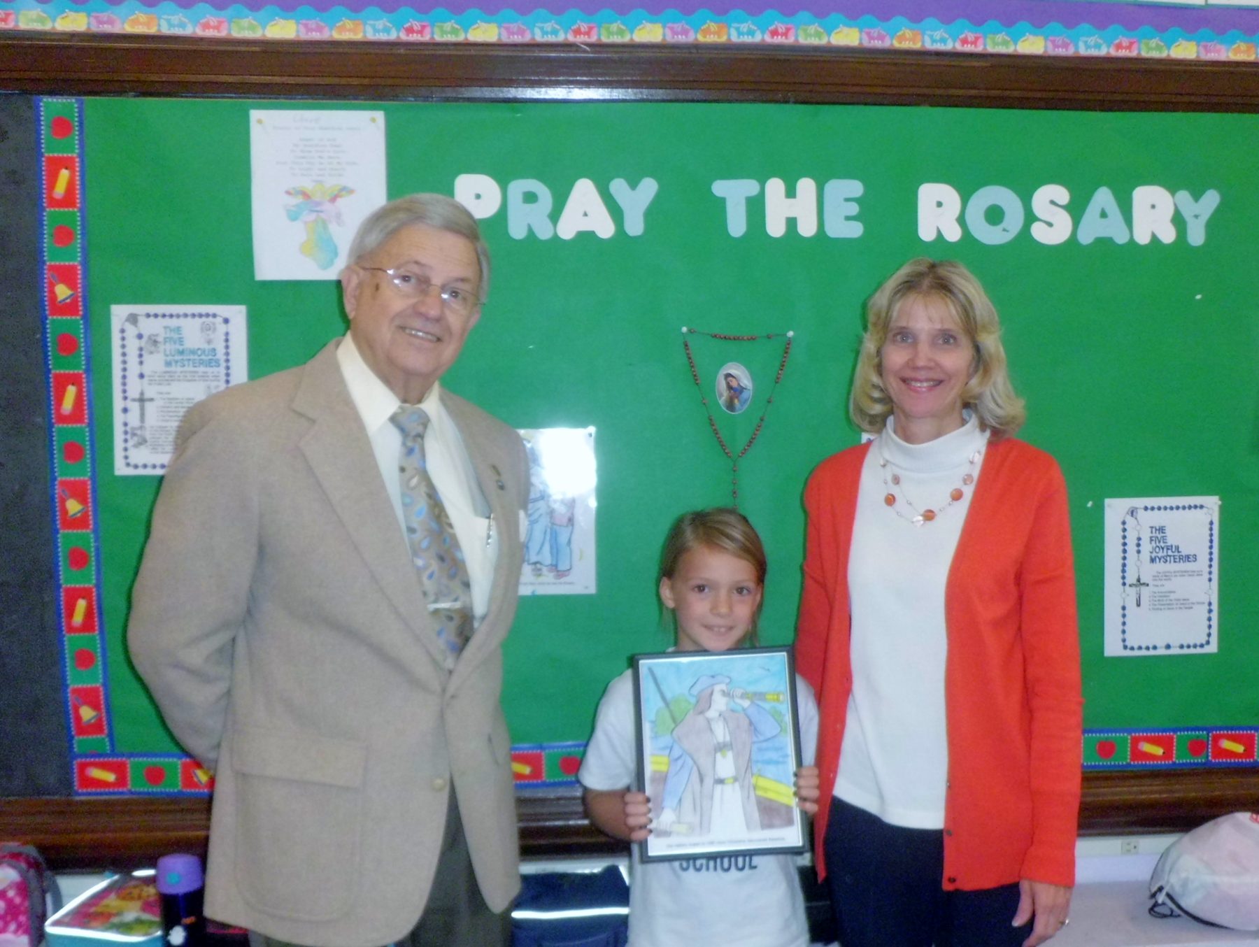 Pictured from left are James Mack, coloring contest coordinator and Keystone UNICO board chairman; coloring contest winner Claire Polishan; and Ms. Carol Lee McDonald, second grade teacher at Saint Mary's Parochial School.