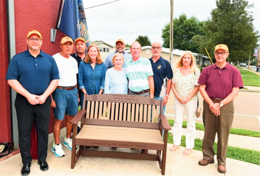 Michael Colangelo, Geno Tempesta, Gene DiVizio, Catherine Needham, Sean Colangelo, Nancy Needham, Joseph Needham, Leo Wentline, Melissa Dworak, and Jim Colangelo are shown during the dedication of the bench in memory of Joseph W. Dougherty Jr. in front of Dunmore Fire Company headquarters on Pine Street.